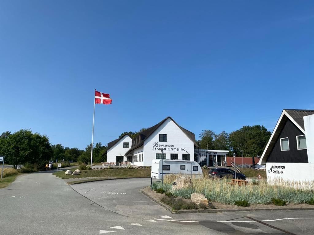 a house with a canadian flag flying over a street at Svalereden Strand Camping Apartments in Frederikshavn