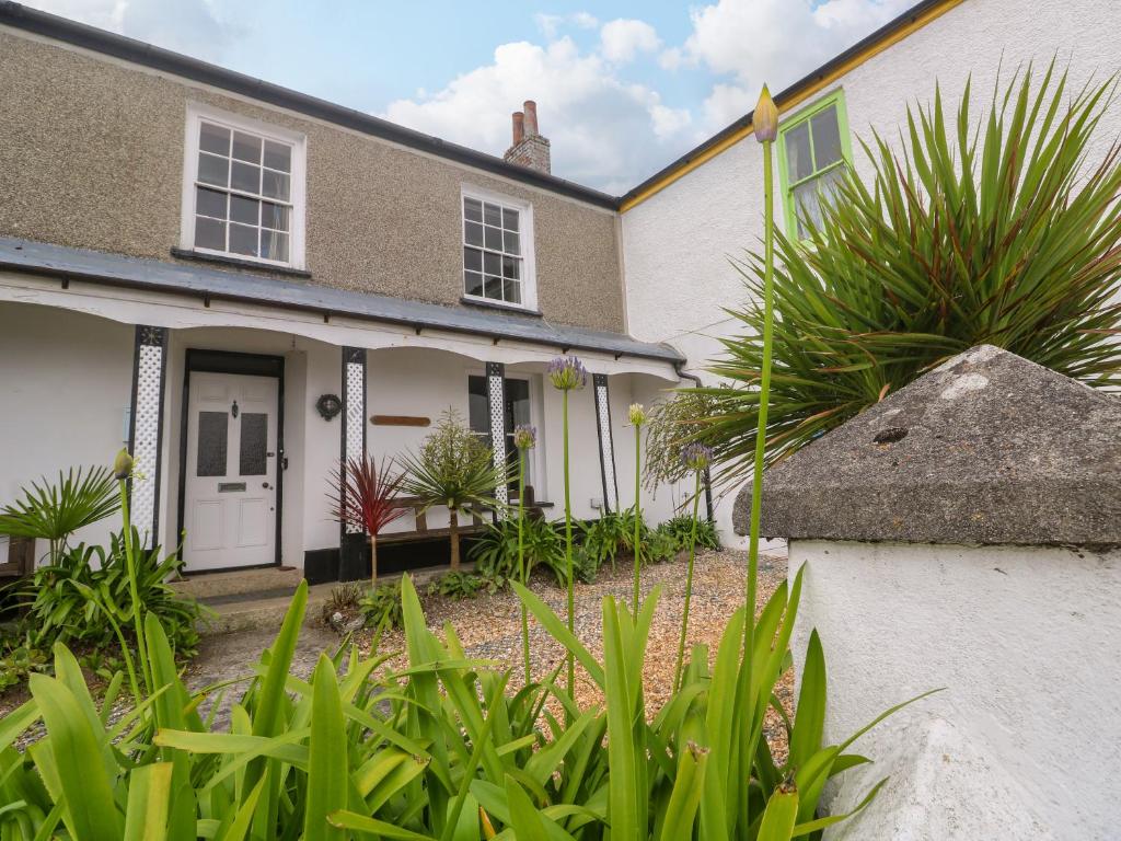 a house with green plants in front of it at 1 Dormer Villas in Porthscatho