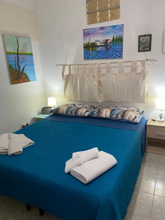 a blue bed with two towels on top of it at Casa vacanza La Ninfea intera casa in Caltagirone