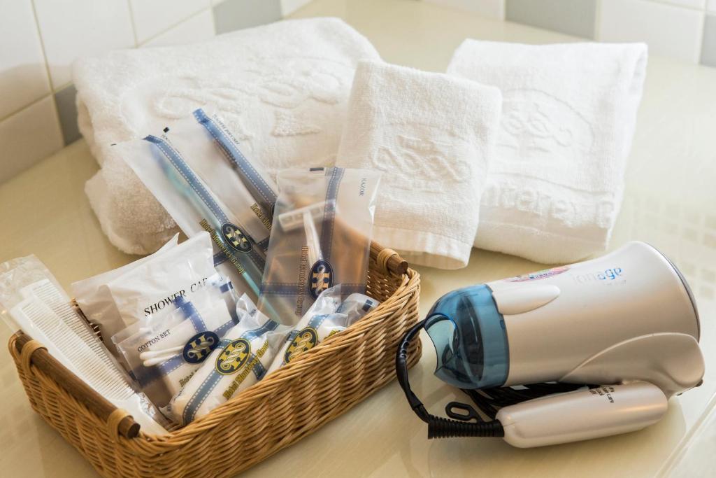 a basket with a hair dryer and towels on a table at Hotel Monterey Grasmere Osaka in Osaka