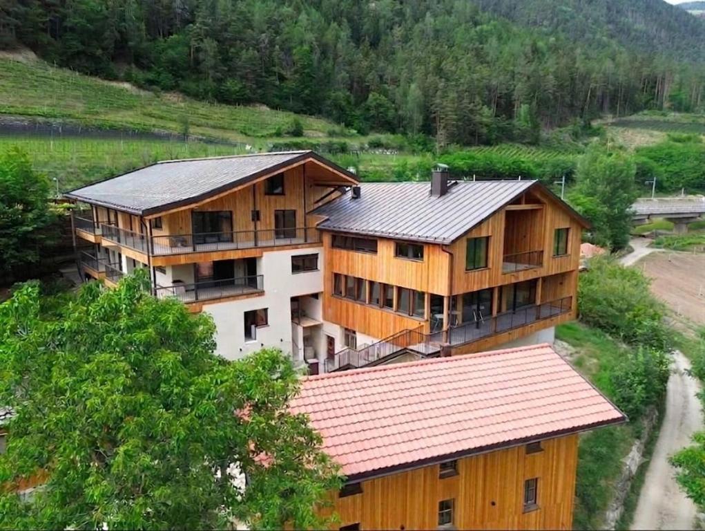 a large wooden house with a metal roof at Weingut Santer Apartments in Mühlbach
