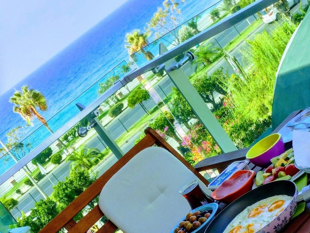 a table with a surfboard on a balcony with the ocean at WEDAT APART On the beach Moda Marine Residence in Alanya