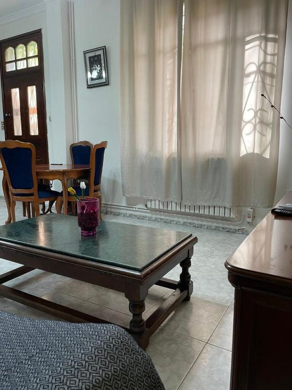 a living room with a coffee table and a dining room at Layna in El Mouradia