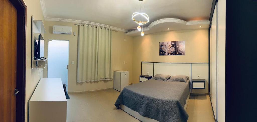a bedroom with a bed and a television in it at Suíte Excellence - 01 in Pirenópolis