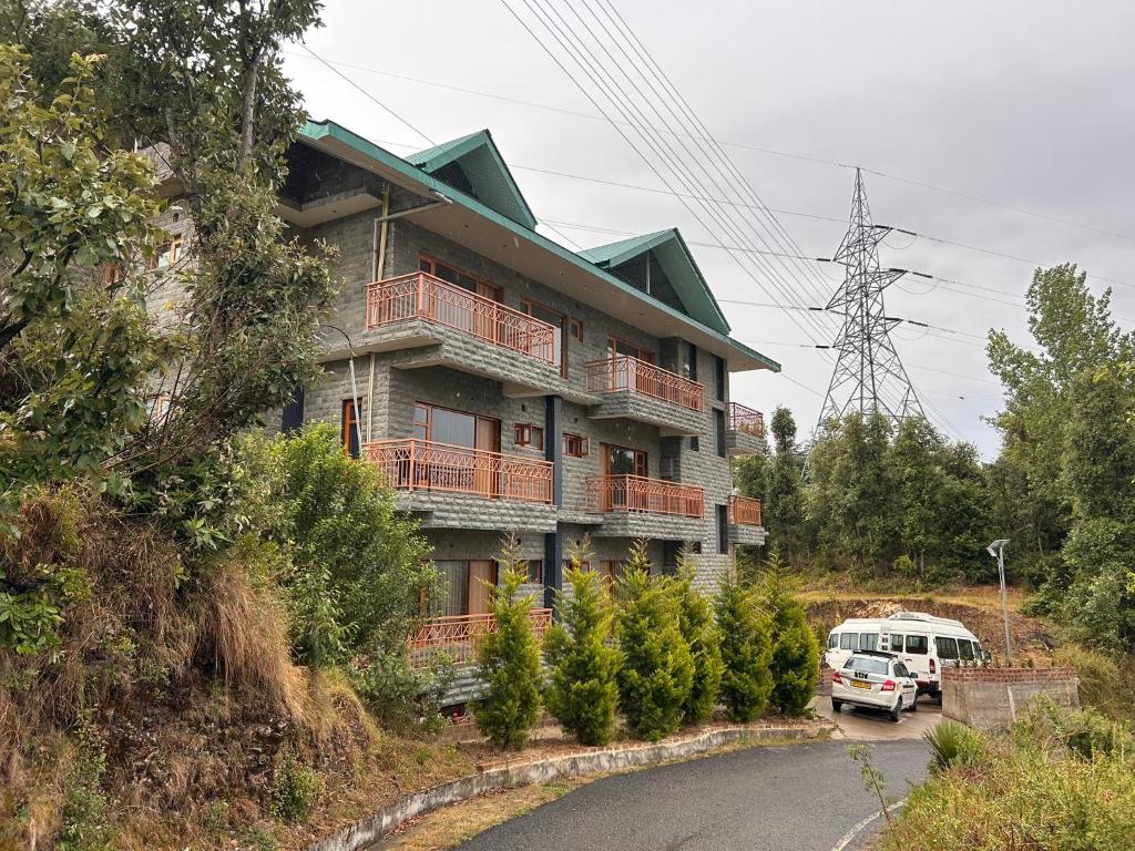 a building with a van parked in front of it at Shalom Hillcrest Inn in Shimla
