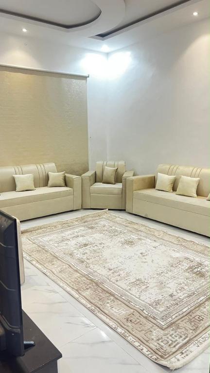 a living room with couches and a large rug at شقه ارضيه in Hail