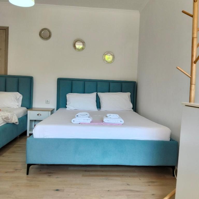 a bedroom with a blue bed with two towels on it at Kostaki spila apartment in Himare