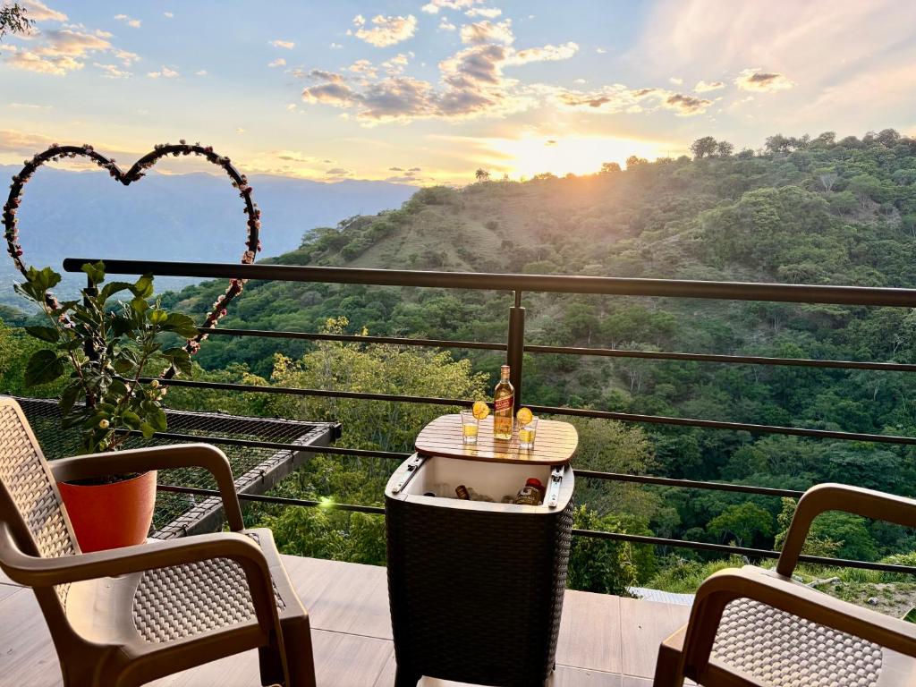 a table on a balcony with a view of a mountain at cabaña emanuel in Sopetrán