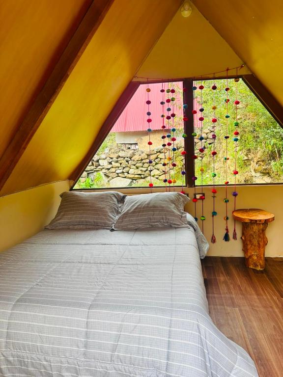 a bedroom with a bed in a tent with a window at Salkantay Glamp in Colcapampa