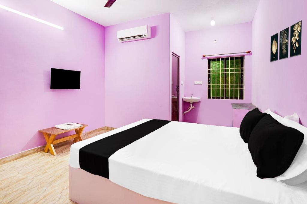 a bedroom with purple walls and a large bed at Hotel O Royal Midlaans in Kālapettai