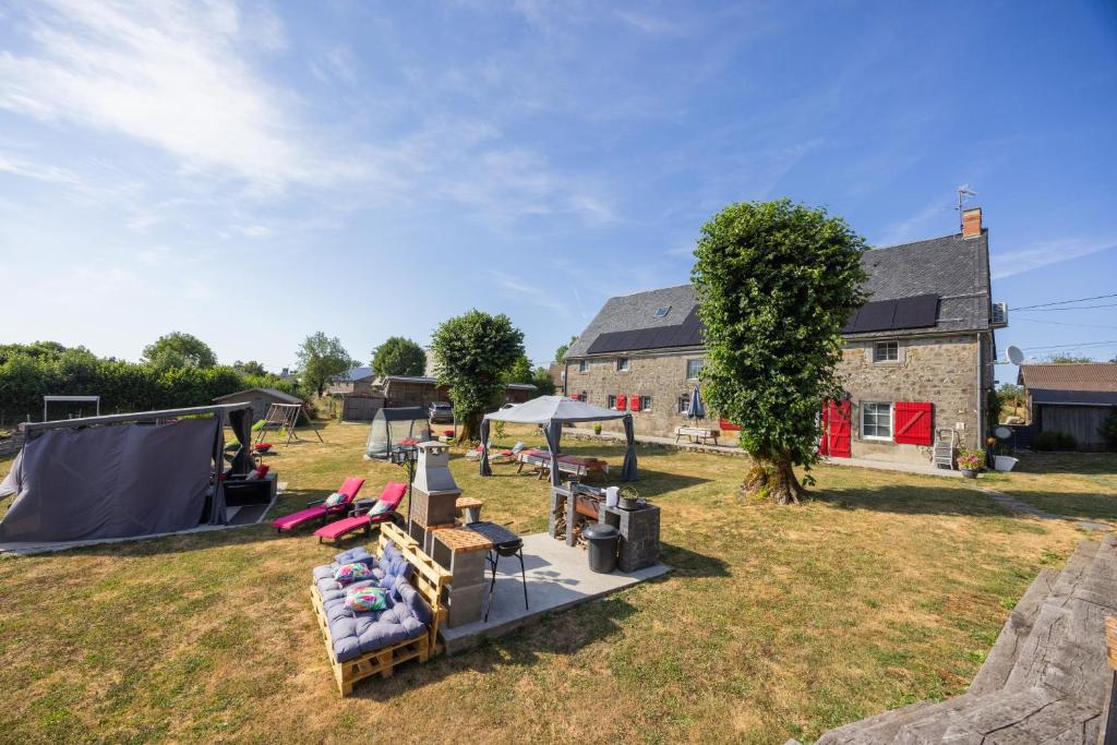 a farmhouse with a table and chairs in a yard at Chambres D'hôtes Histoire D'anges in Singles