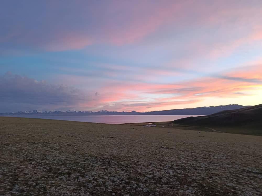 a sunset over a body of water with mountains in the background at Bilalguesthouse in Dzhangyaryk