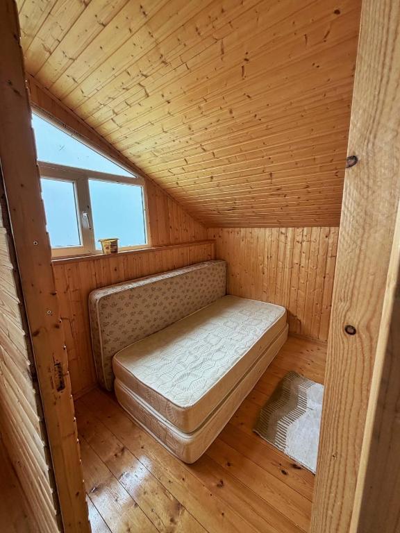ein kleines Zimmer mit einem Bett in einer Holzhütte in der Unterkunft Gomito mta in Ekadiya