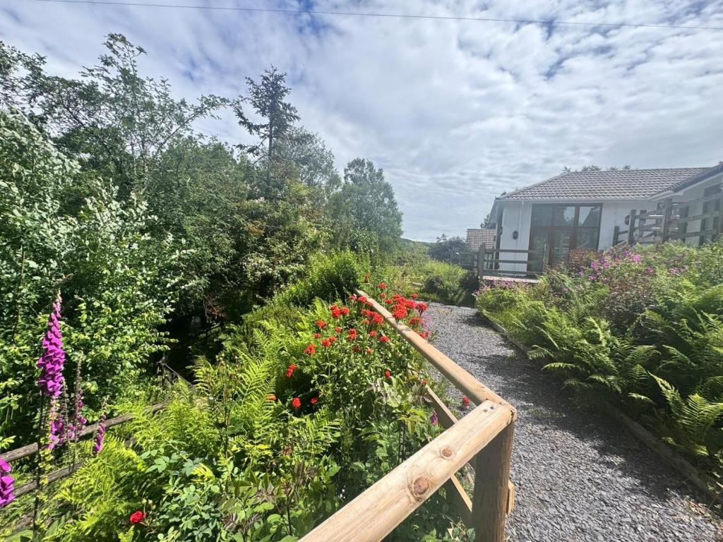 a garden with flowers and a wooden fence at 4 Bed in Llanidloes oc-95968 in Van