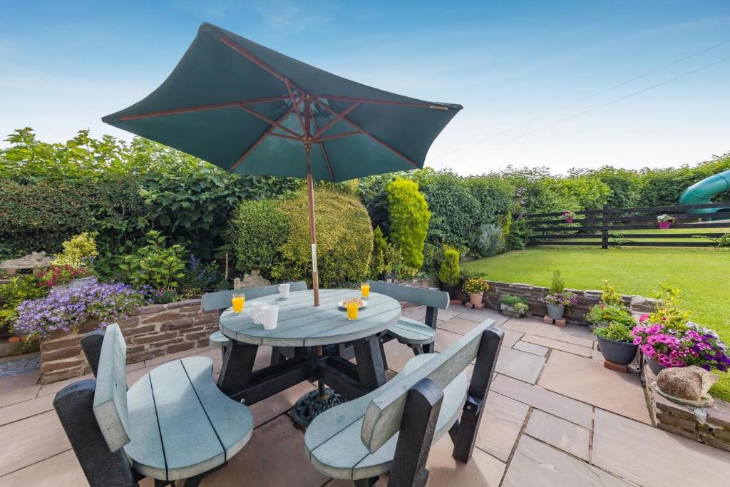 a table and chairs with an umbrella on a patio at 3 Bed in Brecon oc-bn363 in Brecon