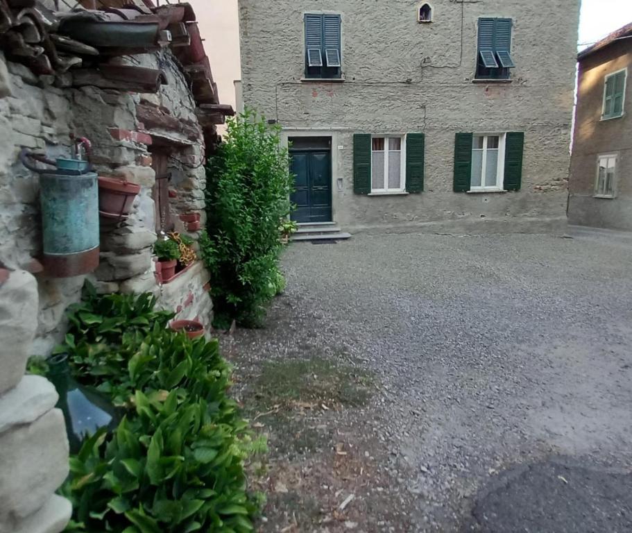 a stone building with a blue door and some plants at La Cascinassa in Tagliolo Monferrato