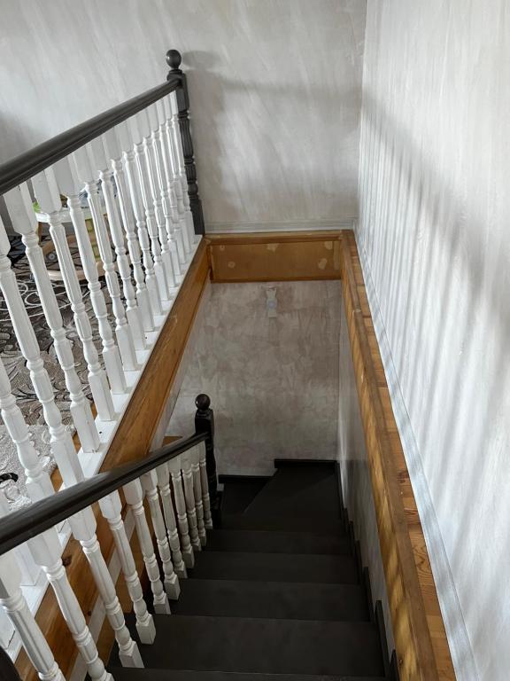 a staircase in a building with white railings at Jumgal Nomad Nest in Kyzart