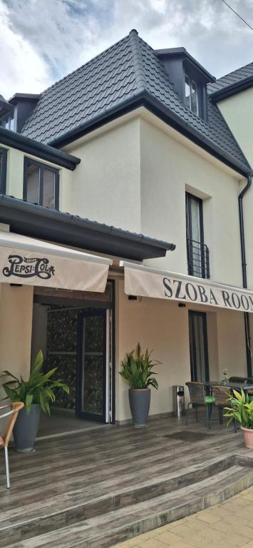 a store with a sign on the front of a building at Central Room Hostel in Balatonszárszó