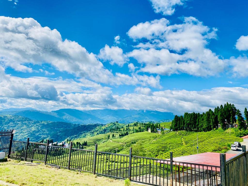 a fence on a hill with mountains in the background at Kanyam Brichyalaya in Suryodaya