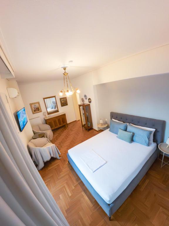 a bedroom with a large white bed and a couch at Central Family Flat Volos in Volos