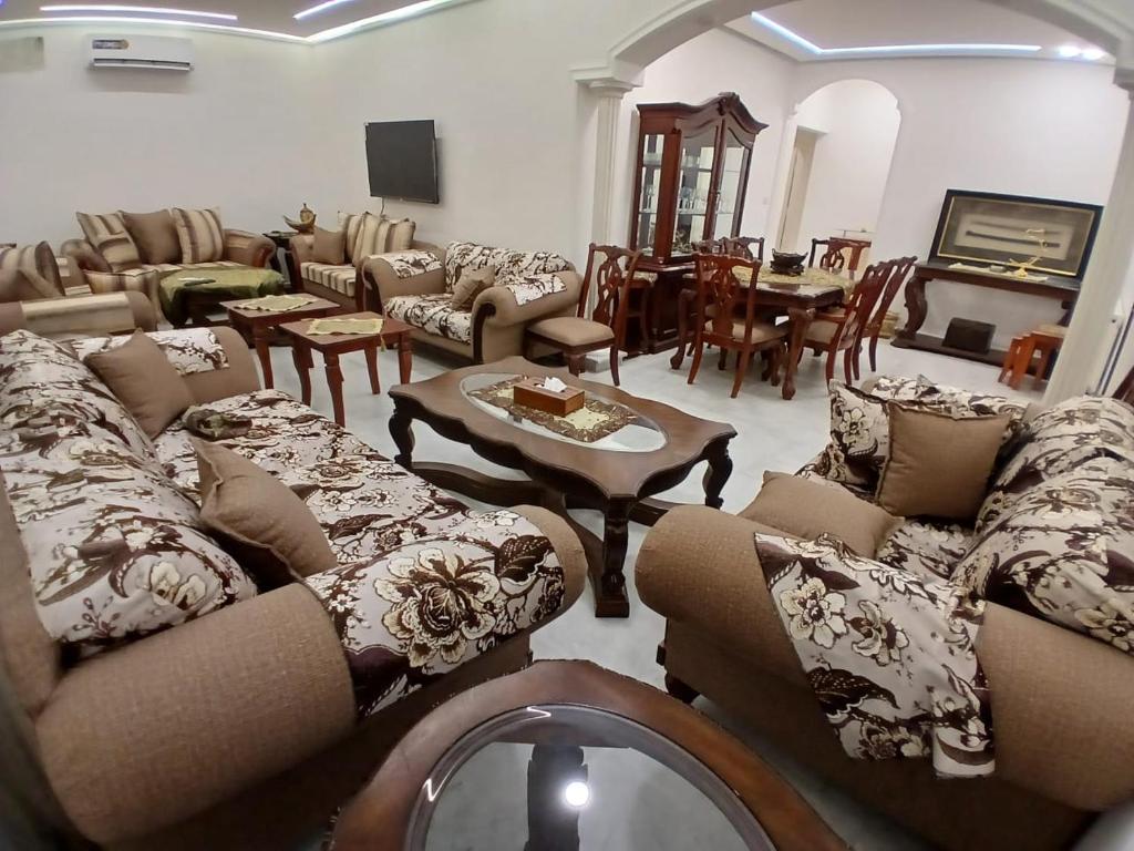 a large living room with couches and a table at California Stay in Amman