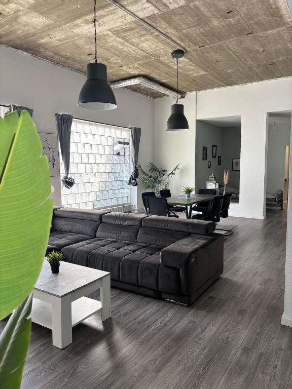 a living room with a black couch and a table at Loft character in Eggenstein-Leopoldshafen