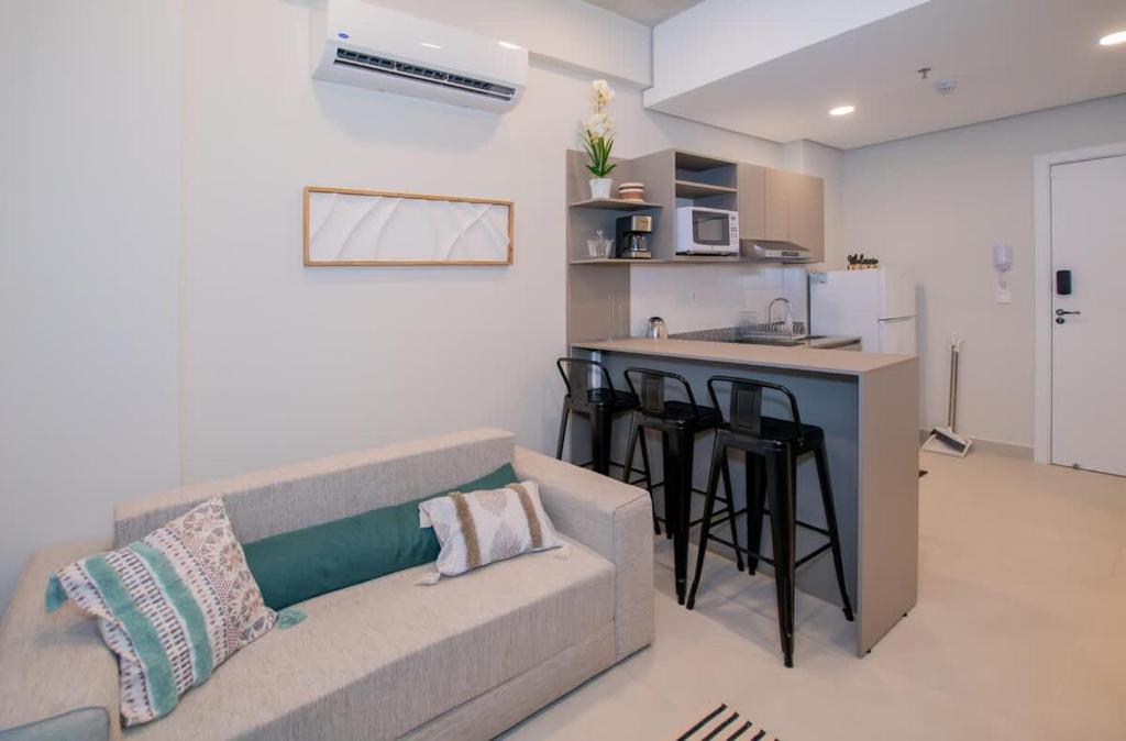 a living room with a couch and a kitchen at Peaceful Stay with Rooftop Pool Access in Fernando de la Mora
