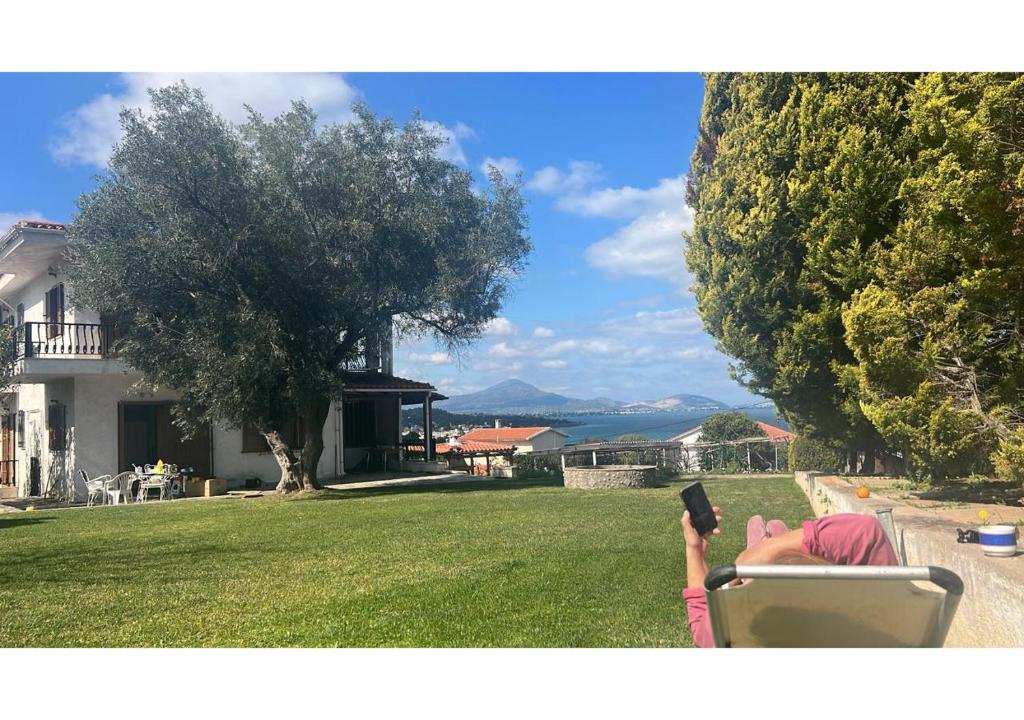 a person laying on a chair in a yard at Zeba apartment 200m from the Sea in Dhílesi