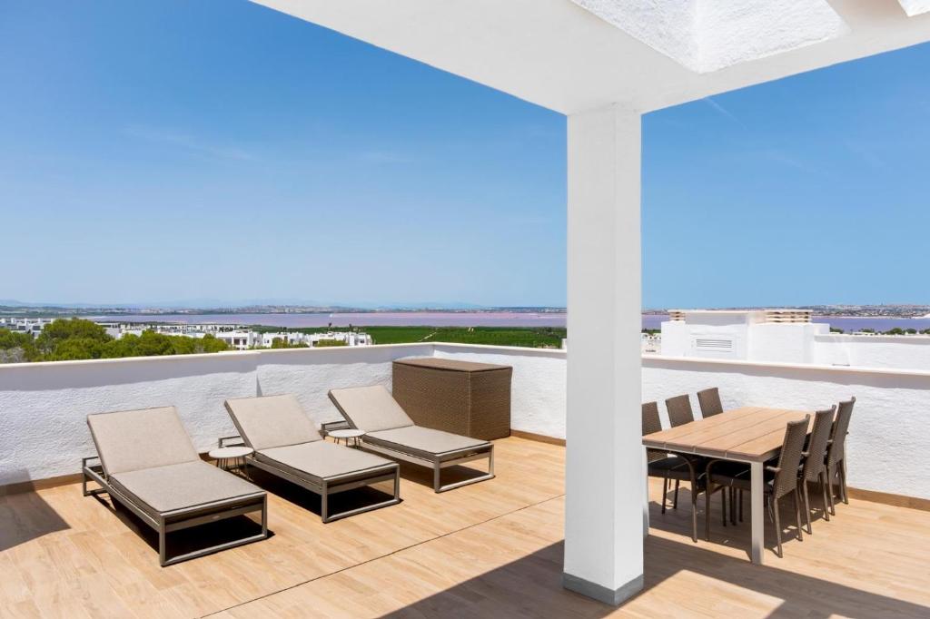a patio with chairs and tables on a roof at Casa juley in Torrevieja