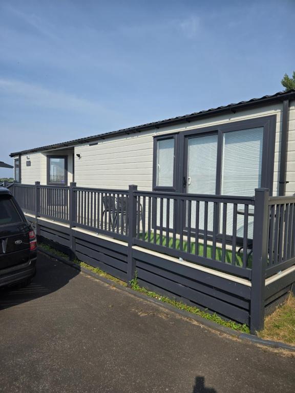 a mobile home with a car parked in front of it at Glen lodge Craig Tara in Ayr