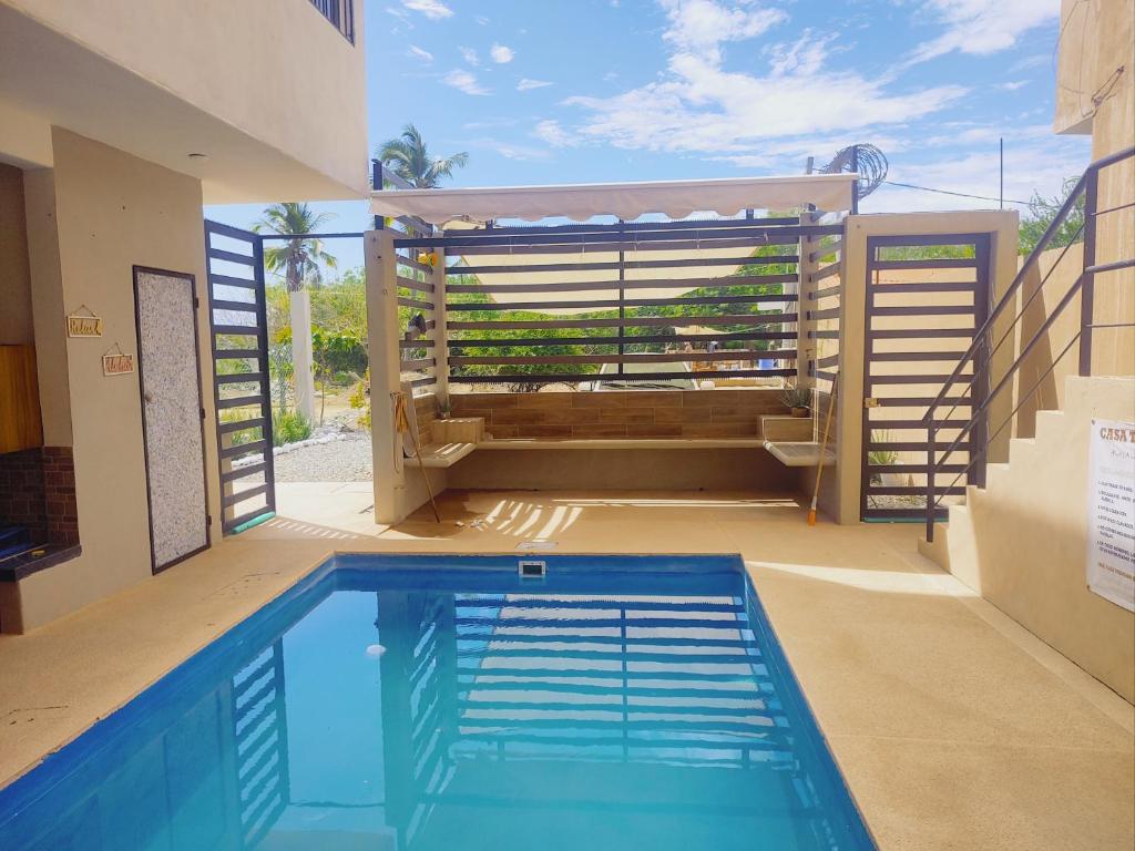 a swimming pool in front of a house at Casa Tania playa larga in Agua de Correa