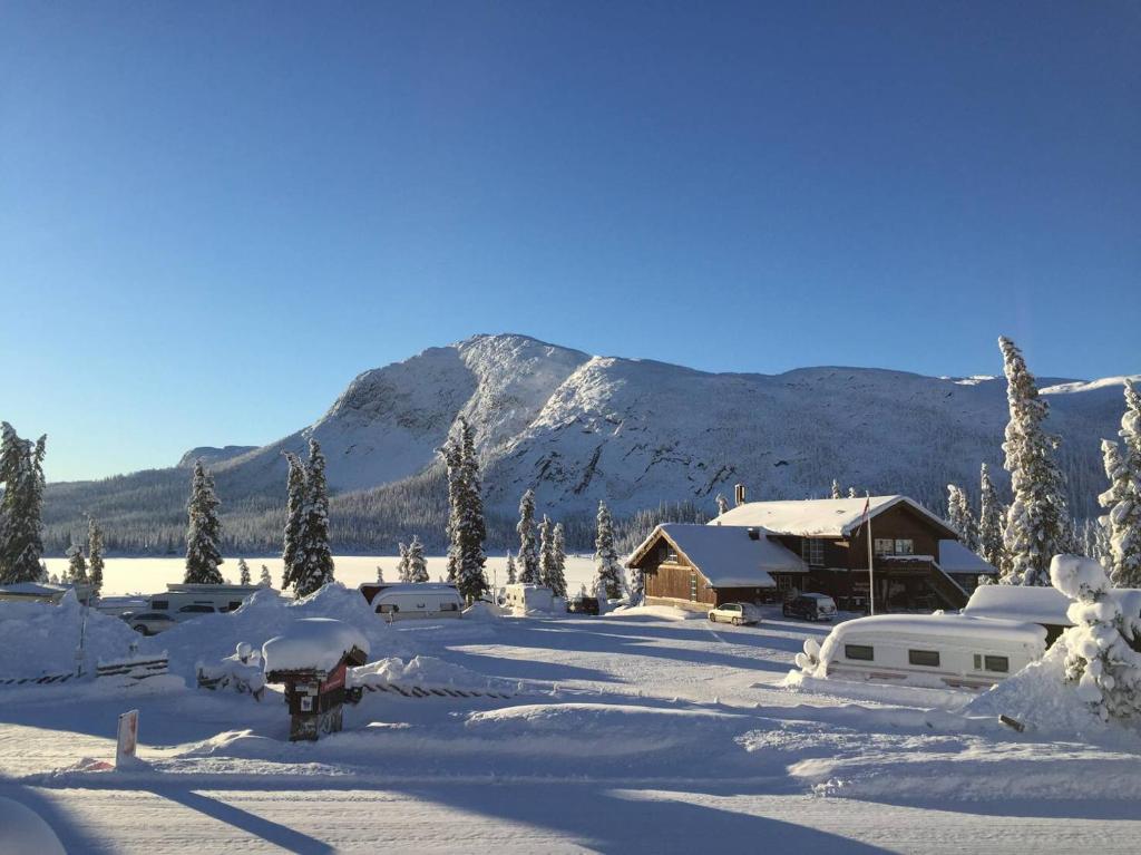 a snow covered cabin with a mountain in the background at Haglebu Turistheim in Haglebu