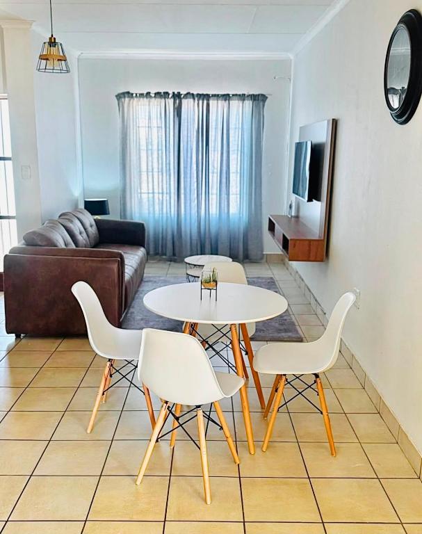 a living room with a table and chairs and a couch at Arise self catering in Burgersfort