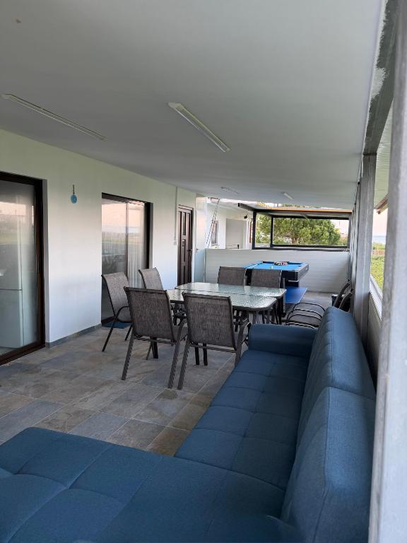 a living room with a couch and a table and chairs at Sea view Kastri in Nei Poroi
