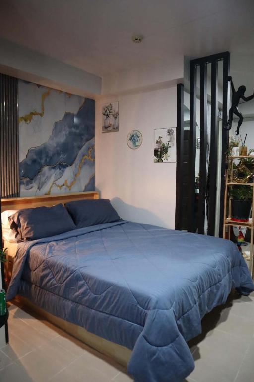a bedroom with a large blue bed in a room at Plumera Mactan Bldg A 108 in Bankal