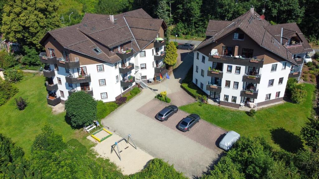 an overhead view of a large house with cars in the yard at Haus Sachsensteinblick in Bad Sachsa