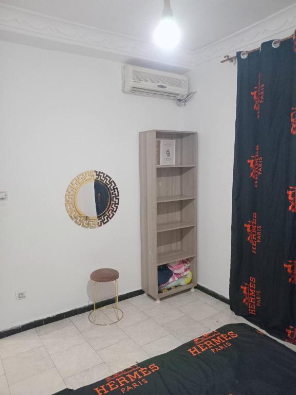 a room with a bed and a mirror and a chair at Aïn turk oran in Aïn El Turk