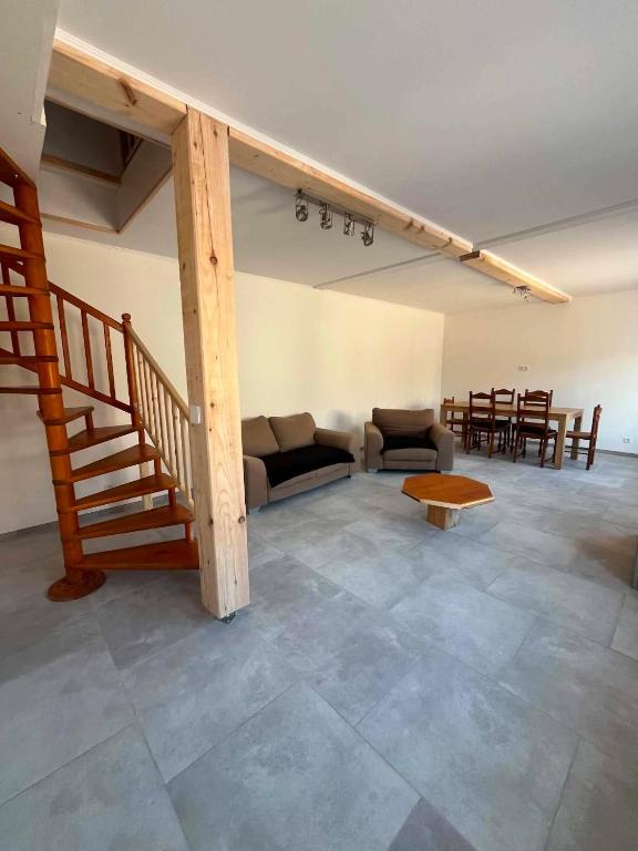 a living room with a staircase and a couch and a table at Chez JC in Drouvin-les-Marais