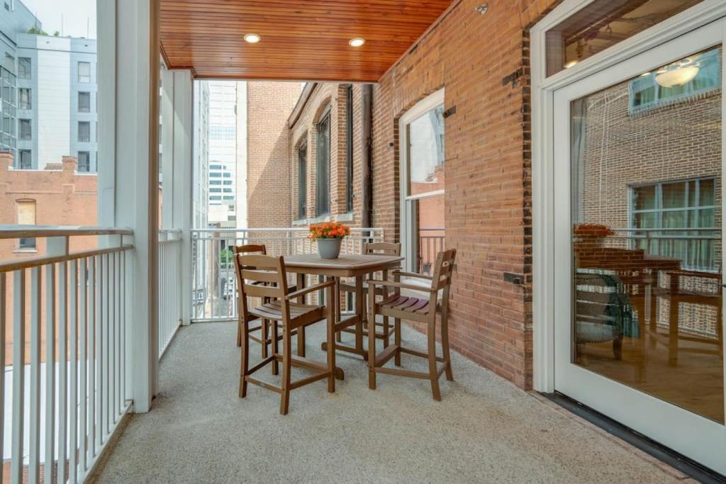 a patio with a table and chairs on a balcony at The Majestic Lofts in Nashville