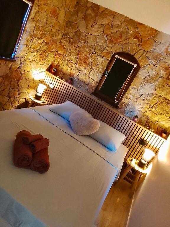 a bedroom with a large bed with a large stone wall at Évasion au calme in Montauroux