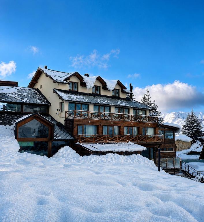 a large house is covered in snow at Hotel Punta Condor in San Carlos de Bariloche