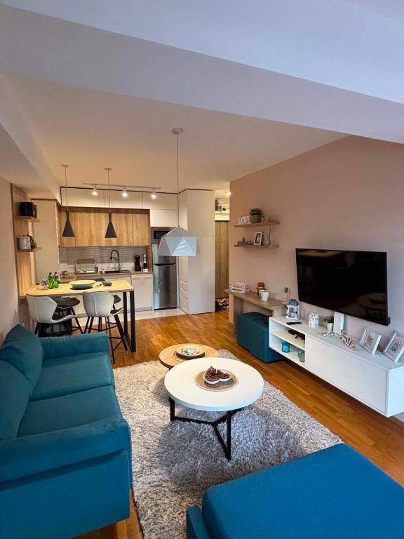 a living room with a blue couch and a table at Lazaro Urban Apartment in Skopje