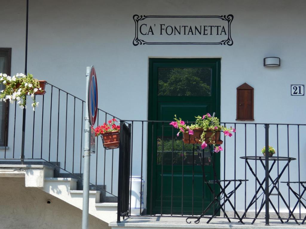 a blue building with a green door and flower pots at Ca' Fontanetta Holiday Home in Caprie