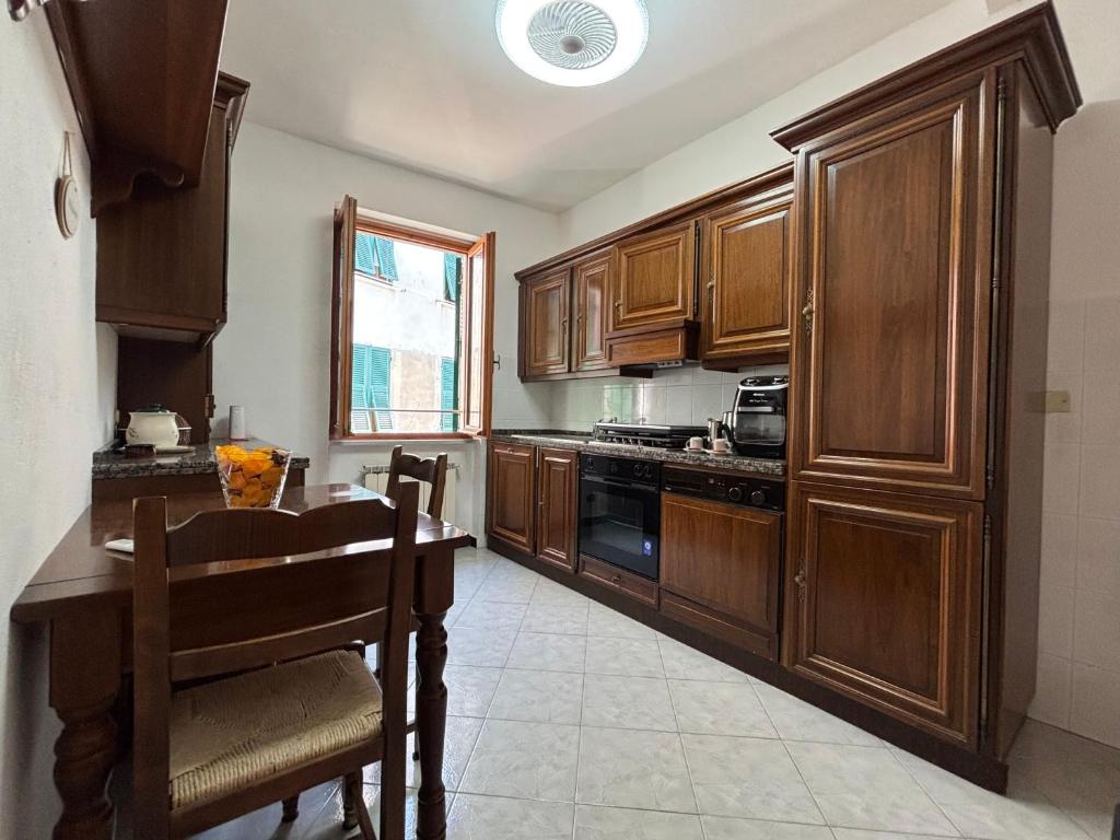 a kitchen with wooden cabinets and a table and a stove at Appartamento Grifo in Vernazza