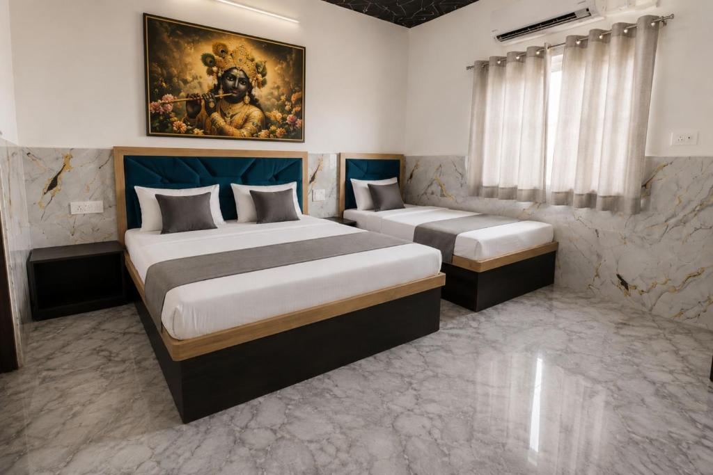 a bedroom with two beds and a painting on the wall at Hotel PKD Vrindavan Near 100 Futta Main Road in Vrindāvan