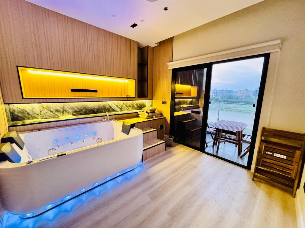 a large bathroom with a tub and a table at جناح فاخر بإطلالة على البحيرة وجاكوزي خاص in Al Khobar