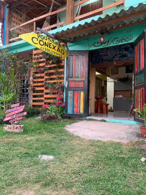 a store with a sign on the front of it at Pousada Conexão in Itaúnas