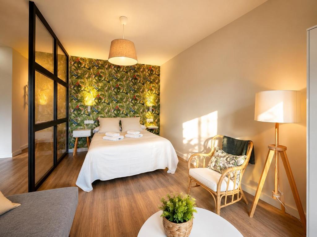 a hotel room with a bed and a chair at Apartamentos Dacosta in Ribadeo