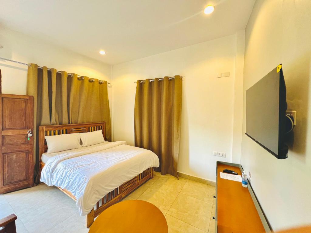 una camera da letto con un letto e una televisione di Panda Hostel a Zanzibar City