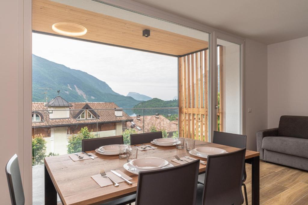 a dining room with a table and a large window at Altavista Aura in Molveno